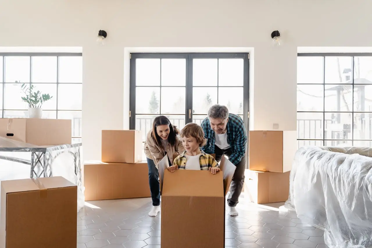Une famille emménage dans sa nouvelle maison, cartons en main
